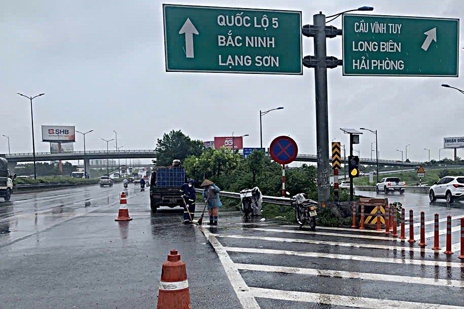 Công nhân 'đội mưa' dọn dẹp đường phố Hà Nội trước kỳ nghỉ Lễ Quốc khánh 2/9- Ảnh 2.